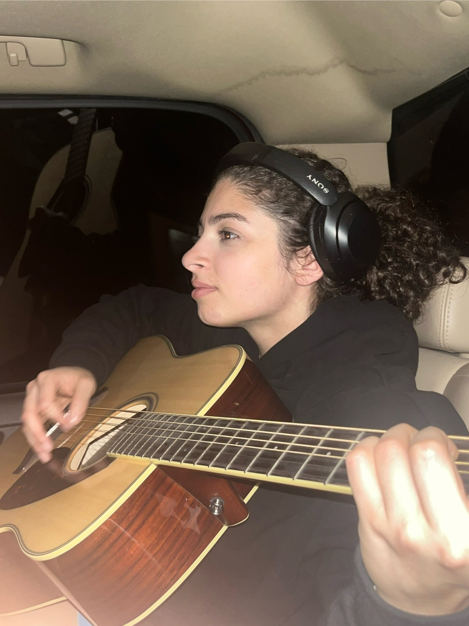 Carinne playing an acoustic guitar